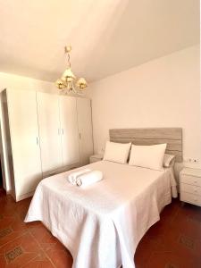 1 dormitorio con 1 cama blanca con manta blanca en APARTAMENTO LA MURALLA, en Córdoba