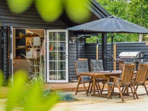 a patio with a table and chairs and an umbrella at Holiday Home Jensen - 175m from the sea in Sealand by Interhome in Tjørneholm