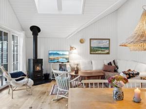 a living room with a couch and a fireplace at Holiday Home Jensen - 175m from the sea in Sealand by Interhome in Tjørneholm
