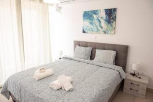 a bedroom with a bed with two towels on it at Overlooking park flat close to the Piraeus Port-(DRAP-A7) in Piraeus