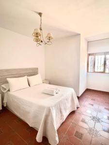 1 dormitorio con 1 cama con manta blanca en APARTAMENTO LA MURALLA, en Córdoba