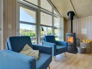 - un salon avec deux chaises bleues et une cheminée dans l'établissement Holiday Home Eicke - 12km from the sea in Western Jutland by Interhome, à Oksbøl