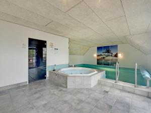 ein großes Bad mit Badewanne in einem Zimmer in der Unterkunft Holiday Home Joona - 12km from the sea in Western Jutland by Interhome in Oksbøl