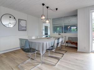 une salle à manger avec une table et des chaises blanches dans l'établissement Holiday Home Joona - 12km from the sea in Western Jutland by Interhome, à Oksbøl
