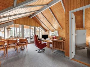 Il dispose d'une cuisine et d'une salle à manger avec des plafonds en bois, une table et des chaises. dans l'établissement Holiday Home Clea - 800m from the sea in Western Jutland by Interhome, à Vejers Strand