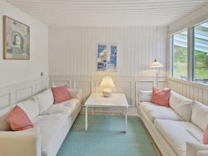 een woonkamer met twee witte banken en een tafel bij Holiday Home Gaelle - 800m from the sea in Western Jutland by Interhome in Vejers Strand