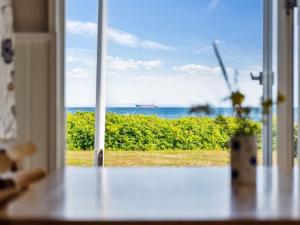 um quarto com vista para o oceano através de uma janela em Holiday Home Mirkka - 50m from the sea in Funen by Interhome em Asperup