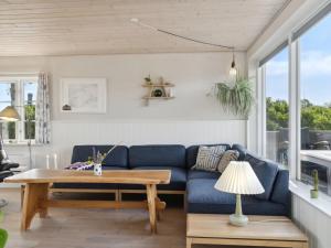 salon z niebieską kanapą i stołem w obiekcie Holiday Home Mirkka - 50m from the sea in Funen by Interhome w mieście Asperup