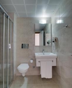 La salle de bains est pourvue de toilettes, d'un lavabo et d'une douche. dans l'établissement Comfort Ada Class Hotel, à Kusadası