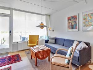 a living room with a blue couch and a table at Apartment Eske - 50m from the sea in Western Jutland by Interhome in Fanø