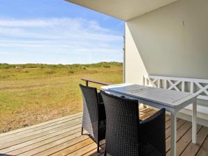 a patio with a table and chairs on a deck at Apartment Eske - 50m from the sea in Western Jutland by Interhome in Fanø