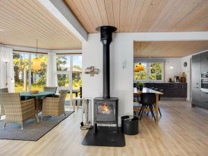 a fireplace in a living room with a table and a kitchen at Holiday Home Laila - all inclusive - 1-2km from the sea in Western Jutland by Interhome in Vejers Strand