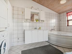 uma casa de banho branca com uma banheira e um lavatório em Holiday Home Jytte - 1-7km from the sea in NW Jutland by Interhome em Thisted