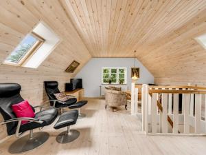 een woonkamer met een houten plafond en stoelen bij Holiday Home Soria - all inclusive - 600m to the inlet by Interhome in Vemb