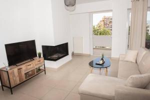 uma sala de estar com um sofá e uma televisão de ecrã plano em Overlooking park flat close to the Piraeus Port-(DRAP-A7) em Piraeus
