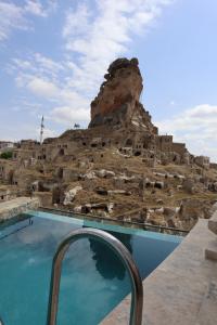 a swimming pool in front of a rock formation at Portal Cappadocia Hotel in Ortahisar