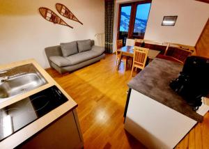 a kitchen and living room with a couch and a table at The Loft in Wagrain