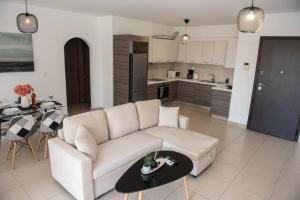 sala de estar con sofá blanco y cocina en Overlooking park flat close to the Piraeus Port-(DRAP-A7), en Pireo