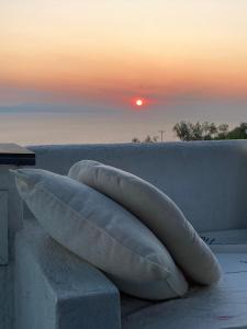 una almohada sentada en una cornisa con una puesta de sol en el fondo en VILLA AZUL, en Centro histórico de Alónnisos