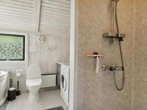 La salle de bains est pourvue de toilettes et d'une douche. dans l'établissement Holiday Home Asko - 350m from the sea in Djursland and Mols by Interhome, à Ebeltoft