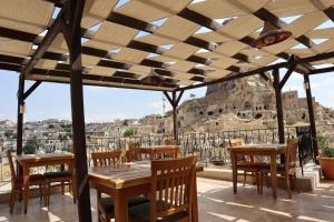 a patio with tables and chairs and a view of the acropolis at Portal Cappadocia Hotel in Ortahisar