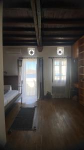 a bedroom with a bed and two windows and a rug at Planitis Lighthouse View in Panormos