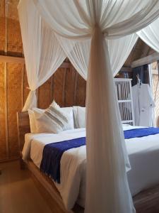 a bedroom with two beds with a canopy at Pondok Bali Volcano in Kubupenlokan