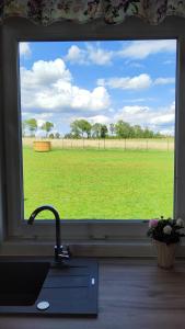 a kitchen window with a view of a field at #MazuryOFFline in Giżycko