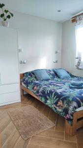 1 dormitorio con 1 cama con edredón azul en #MazuryOFFline en Giżycko