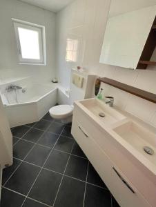 La salle de bains est pourvue d'une baignoire, de toilettes et d'un lavabo. dans l'établissement Fewo Fasanenweg, à Starnberg