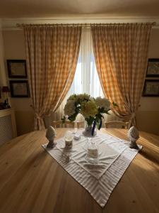 een tafel met een vaas met bloemen op een tafel bij Guesthouse DaVinci in Lamporecchio