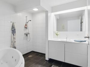a white bathroom with a sink and a mirror at Apartment Geert - 25m from the sea in Djursland and Mols by Interhome in Ebeltoft