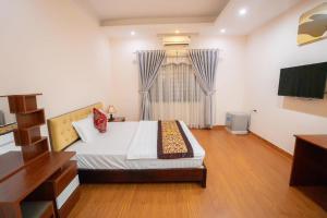 - une chambre avec un grand lit et une télévision dans l'établissement Hoang Yen Hotel - Gần đại học Sư Phạm TN, à Thái Nguyên