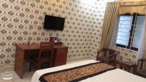 - une chambre avec un bureau et une télévision murale dans l'établissement Hoang Yen Hotel - Gần đại học Sư Phạm TN, à Thái Nguyên