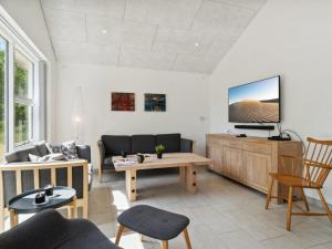 een woonkamer met een bank en een tv bij Holiday Home Swarthovde - from the sea in NE Jutland by Interhome in Hals