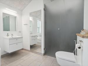 een badkamer met een toilet, een wastafel en een spiegel bij Holiday Home Swarthovde - from the sea in NE Jutland by Interhome in Hals