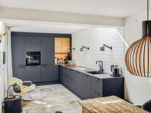 uma cozinha com armários cinzentos e uma bancada em Apartment Kaapo - 1km from the sea in NW Jutland by Interhome em Blokhus