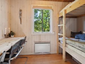a room with a bunk bed and a desk and a window at Holiday Home Anya - 600m from the sea in NE Jutland by Interhome in Hals