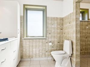 La salle de bains est pourvue de toilettes et d'une fenêtre. dans l'établissement Holiday Home Floriane - 50m from the sea in NE Jutland by Interhome, à Hals