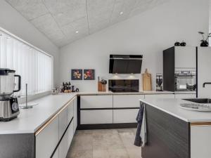 une cuisine avec comptoirs blancs et grand appareil dans l'établissement Holiday Home Aaran - 700m from the sea in NW Jutland by Interhome, à Blokhus