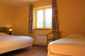 een slaapkamer met 2 bedden en een raam bij La Bullote - Gîtes - Paris Roissy in Villeneuve-sous-Dammartin