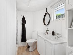 ein weißes Bad mit einem WC und einem Waschbecken in der Unterkunft Holiday Home Kielo - all inclusive - 200m to the inlet by Interhome in Løgstør