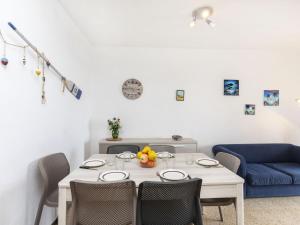 a dining room with a white table and chairs at Apartment Riells Platja by Interhome in L'Escala