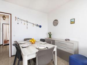 a white dining room with a white table and chairs at Apartment Riells Platja by Interhome in L'Escala