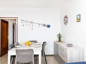 a white dining room with a white table and chairs at Apartment Riells Platja by Interhome in L'Escala +13 photos