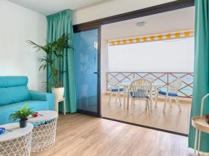 uma sala de estar com um sofá azul e uma mesa em Apartment Blue Neptuno-2 by Interhome em Puerto de Santiago