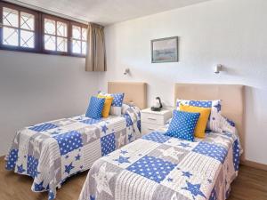 um quarto com 2 camas com lençóis azuis e brancos em Apartment Blue Neptuno-2 by Interhome em Puerto de Santiago