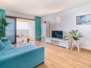 uma sala de estar com um sofá azul e uma televisão em Apartment Blue Neptuno-2 by Interhome em Puerto de Santiago