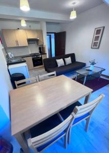a kitchen and living room with a wooden table and chairs at Flat 8 near Westfield Centre, 1 Bedroom, 1 Bathroom flat in London