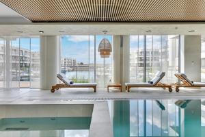 a lobby with chairs and a pool in a building at GRANO APARTMENTS Solmarina SPA & Wellness in Wiślinka